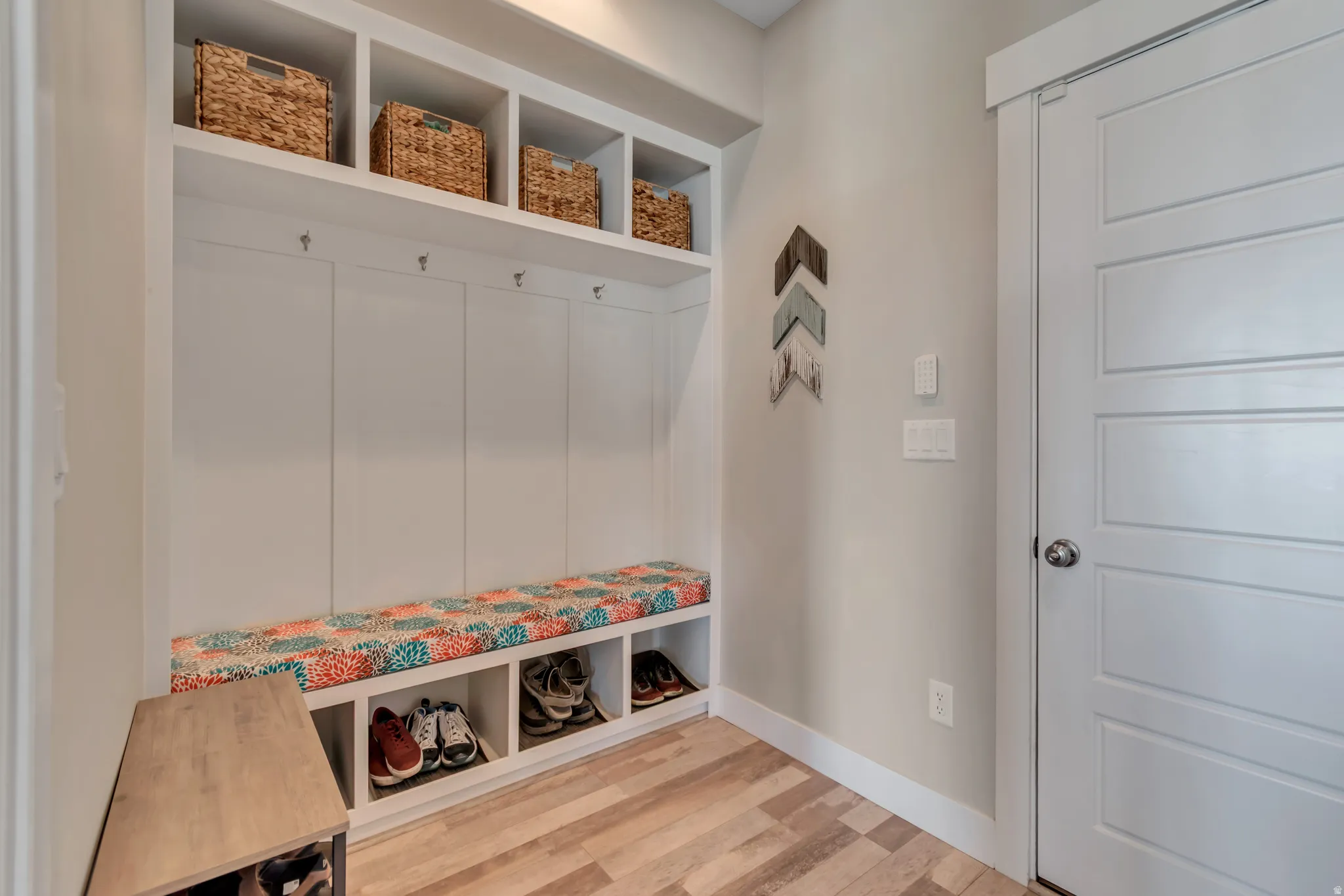 Mudroom featuring light wood-style floors and baseboards