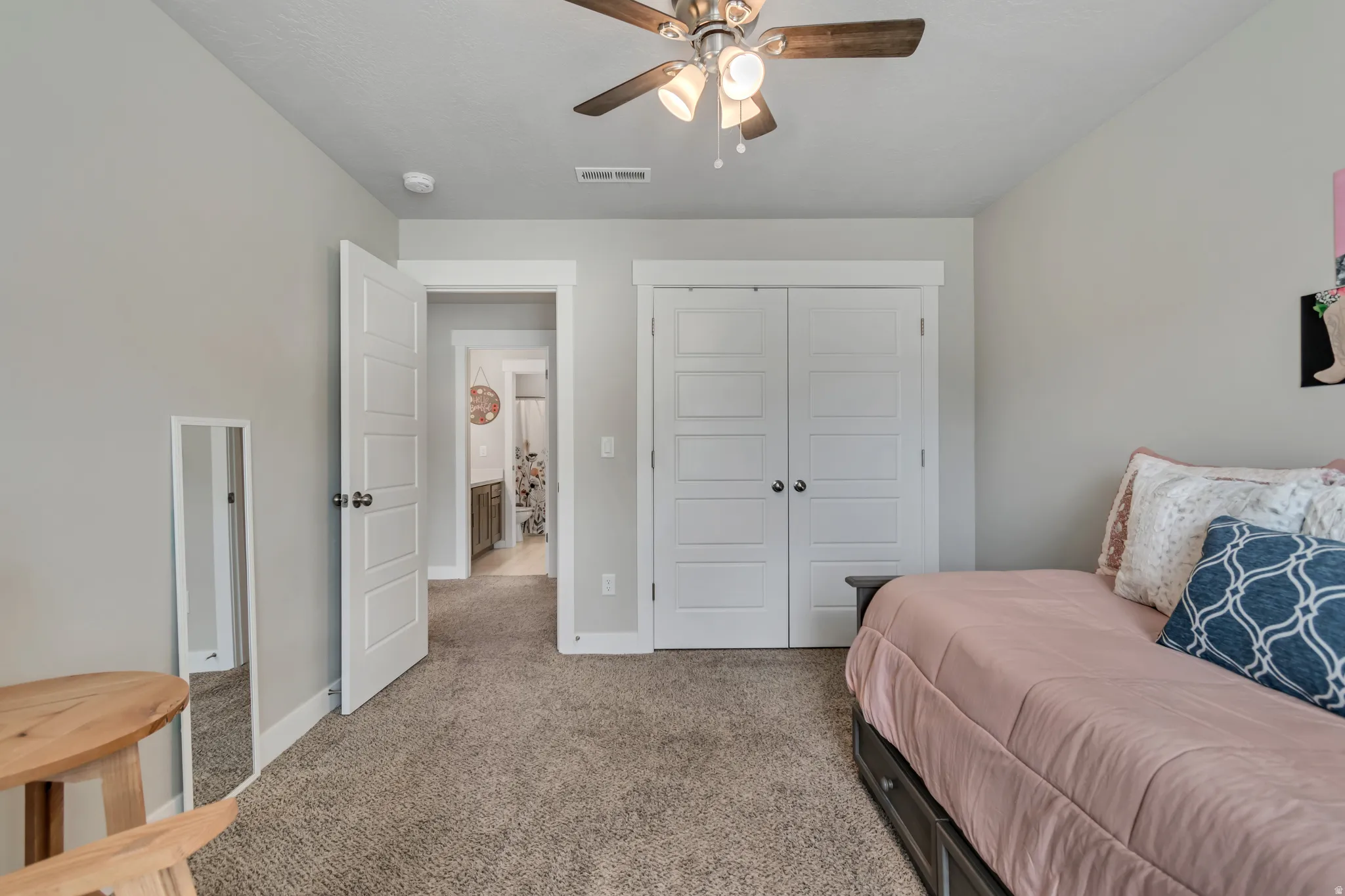 Carpeted bedroom featuring a closet and a ceiling fan