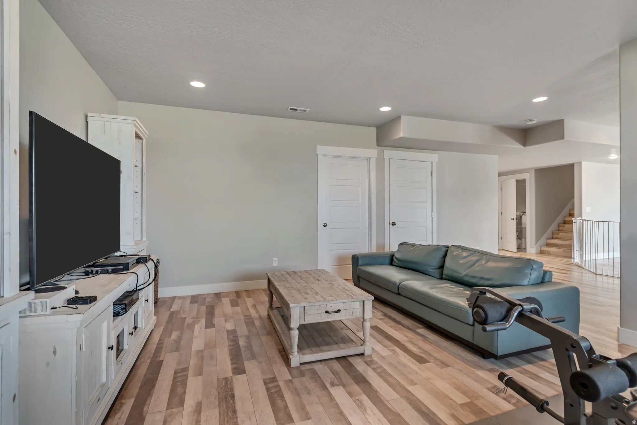 Living area featuring light wood-style floors and recessed lighting