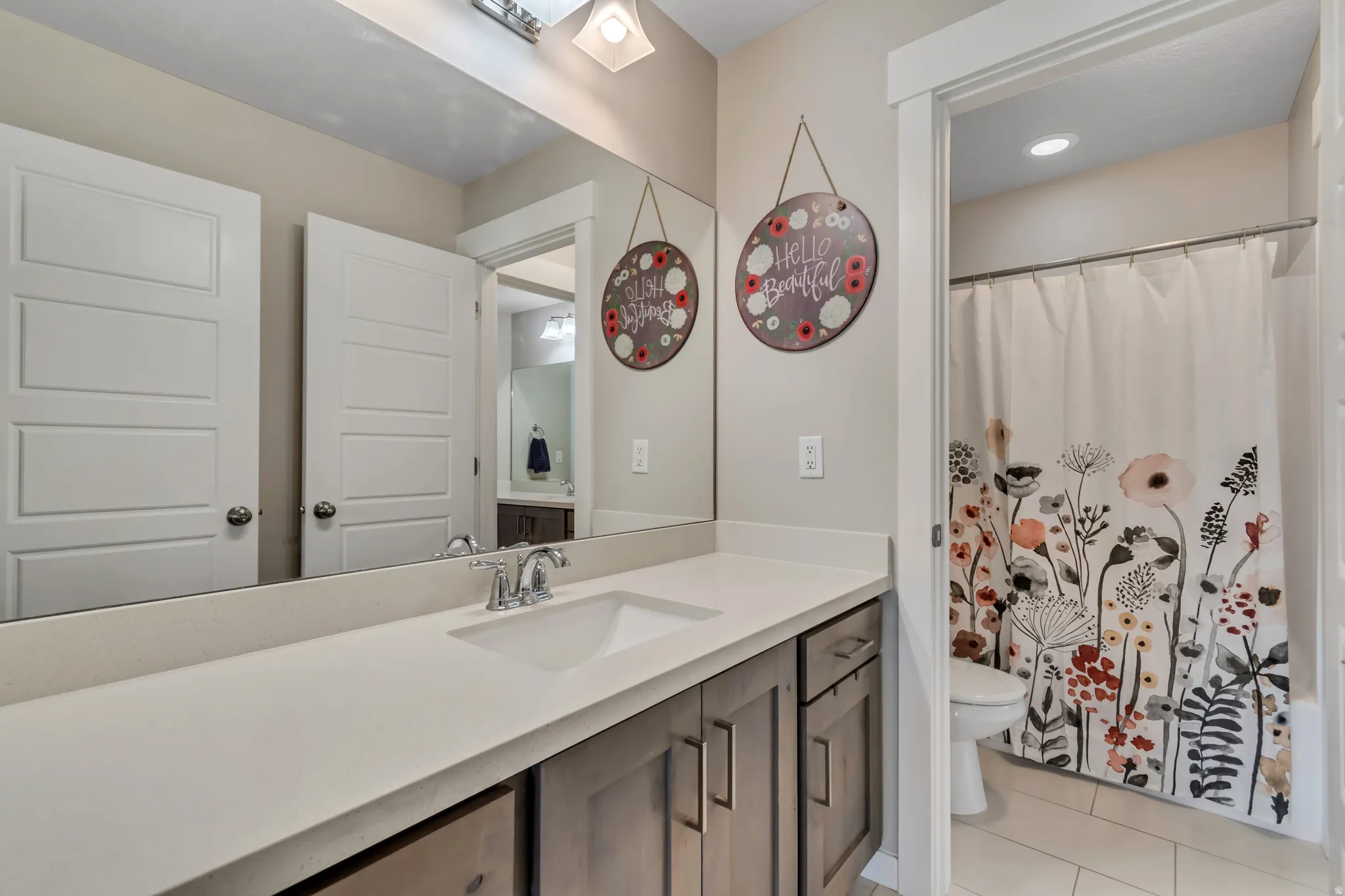Bathroom featuring vanity, a shower with shower curtain, and light tile patterned flooring