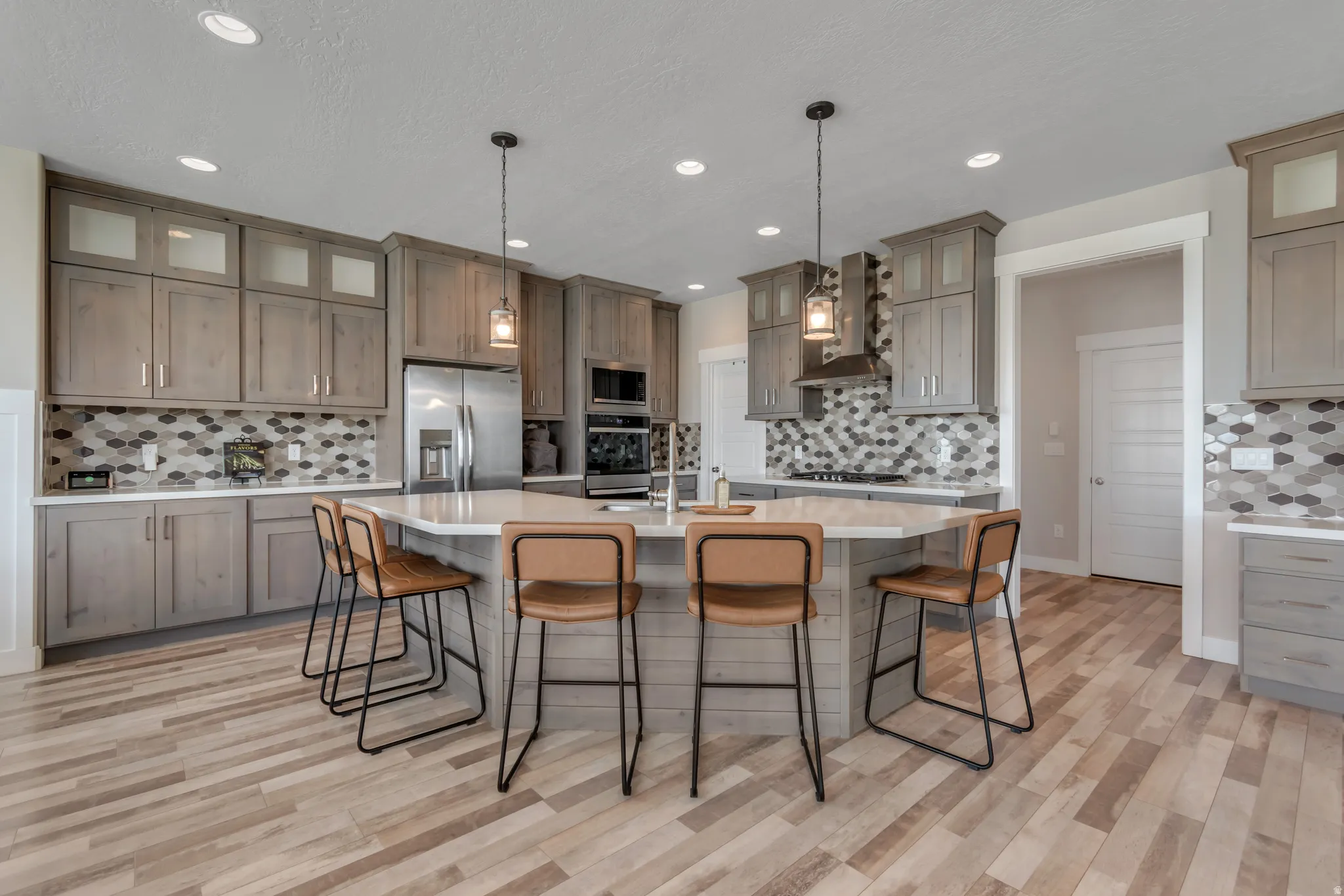 Kitchen with glass fronted cabinets, a breakfast bar area, tasteful backsplash, and stainless steel appliances