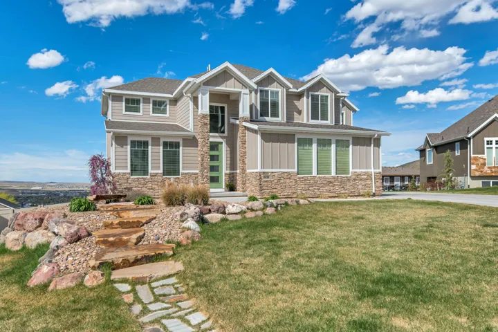 Craftsman-style house with stone siding, board and batten siding, and a front lawn