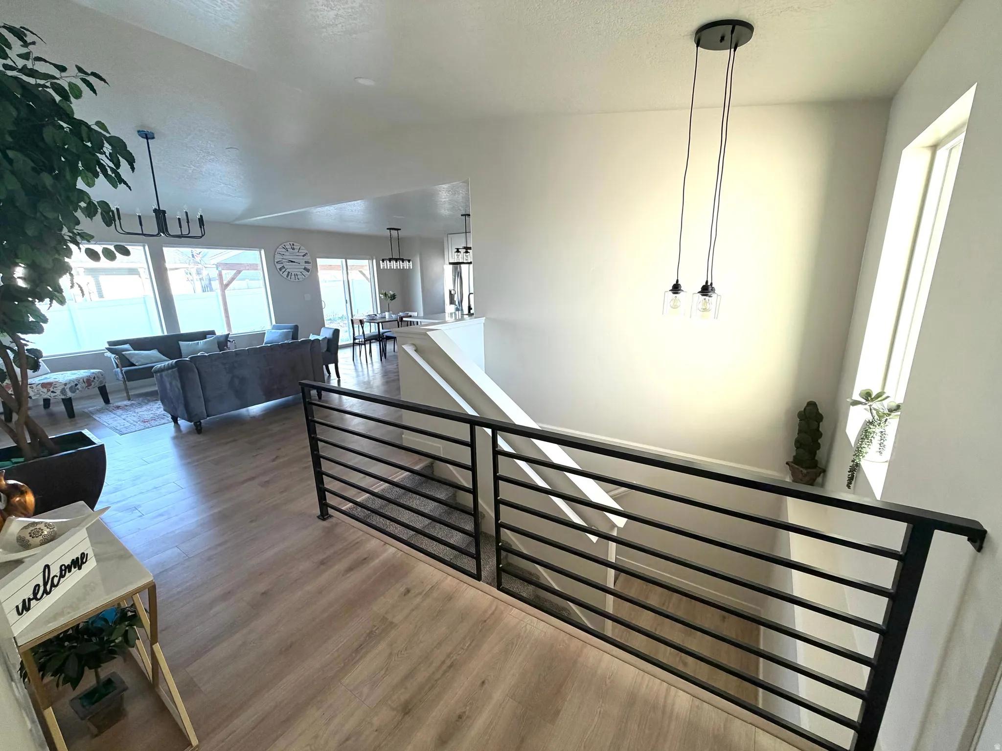 Hallway featuring wood finished floors, lofted ceiling, and an upstairs landing