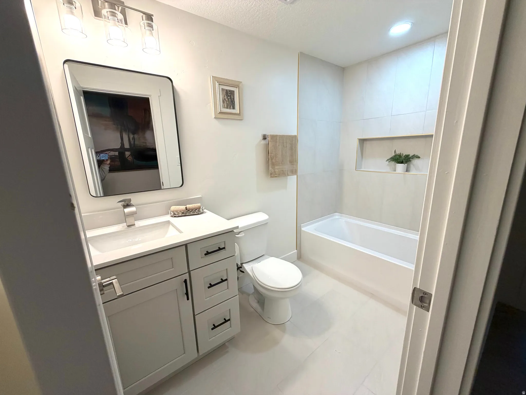 Full bathroom with vanity, a bath, a textured ceiling, and a shower