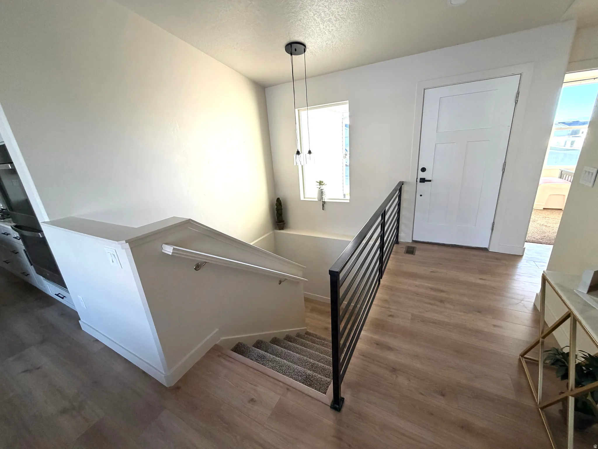 Staircase with wood finished floors and a textured ceiling