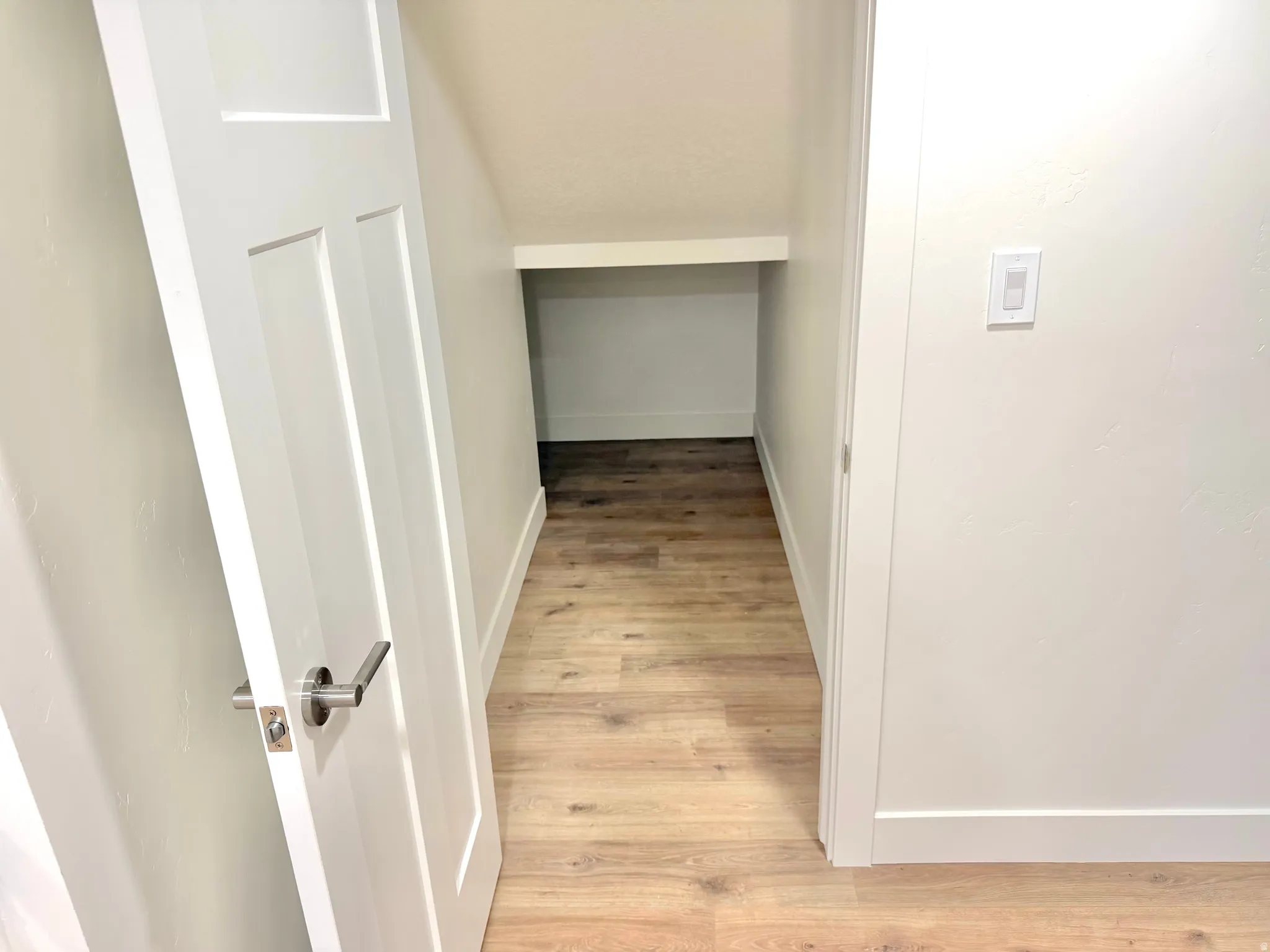 Hallway featuring light wood-type flooring and baseboards
