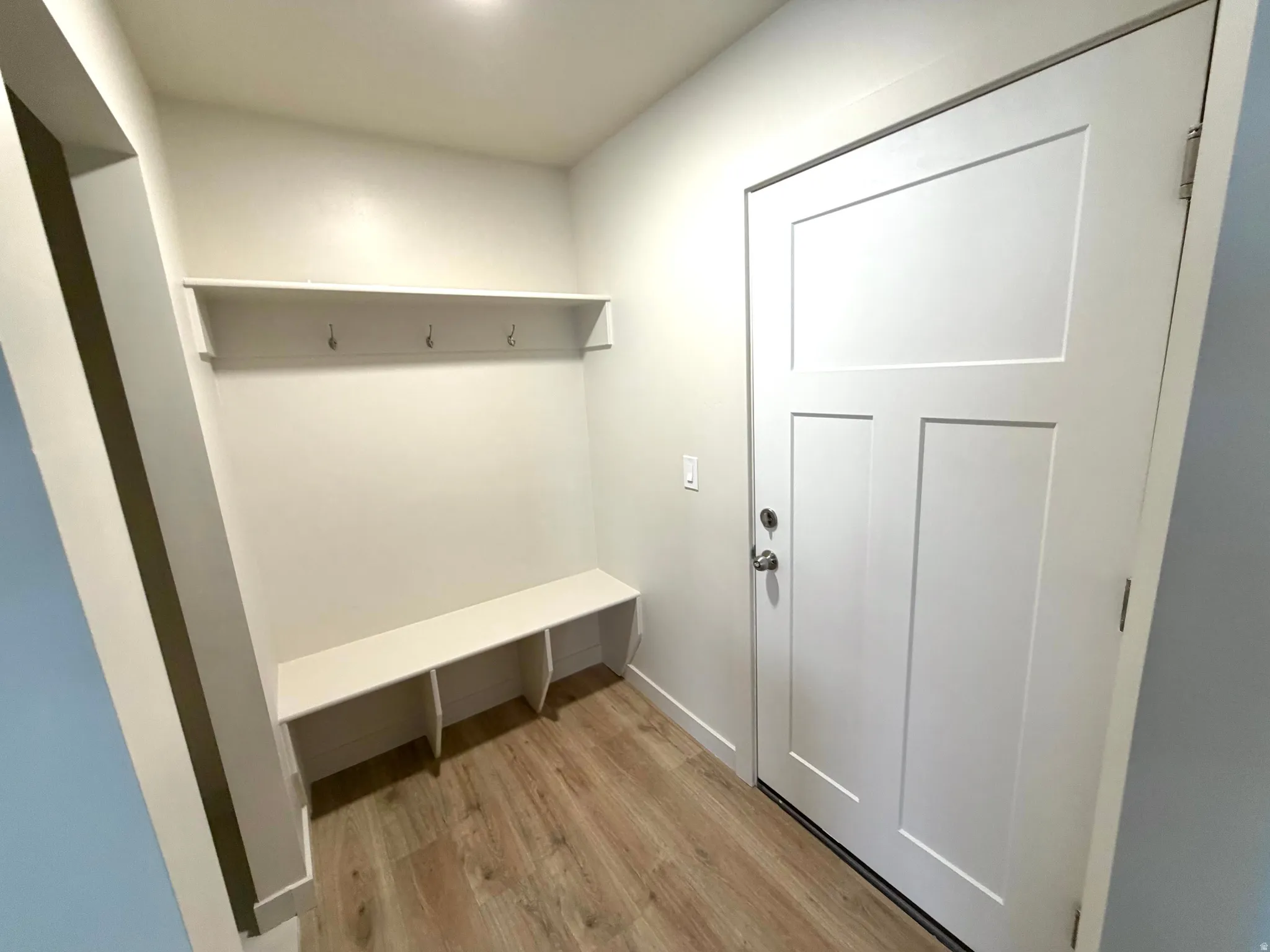 Mudroom featuring light wood-style flooring and baseboards