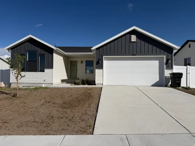 Contemporary ranch-style home featuring white siding and dark vertical board accents