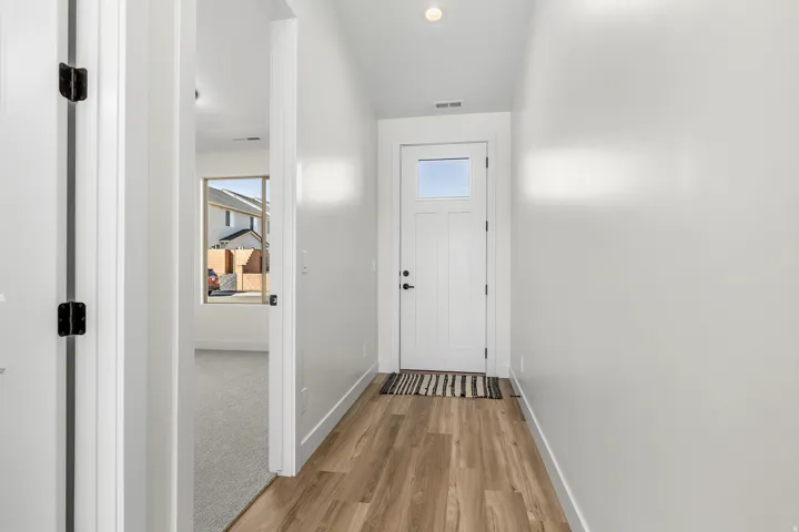 Entryway with wood finished floors and recessed lighting
