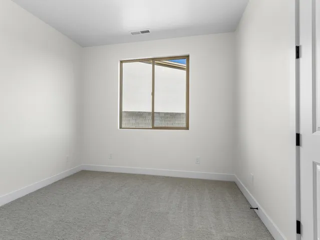 Spare room with light colored carpet and baseboards