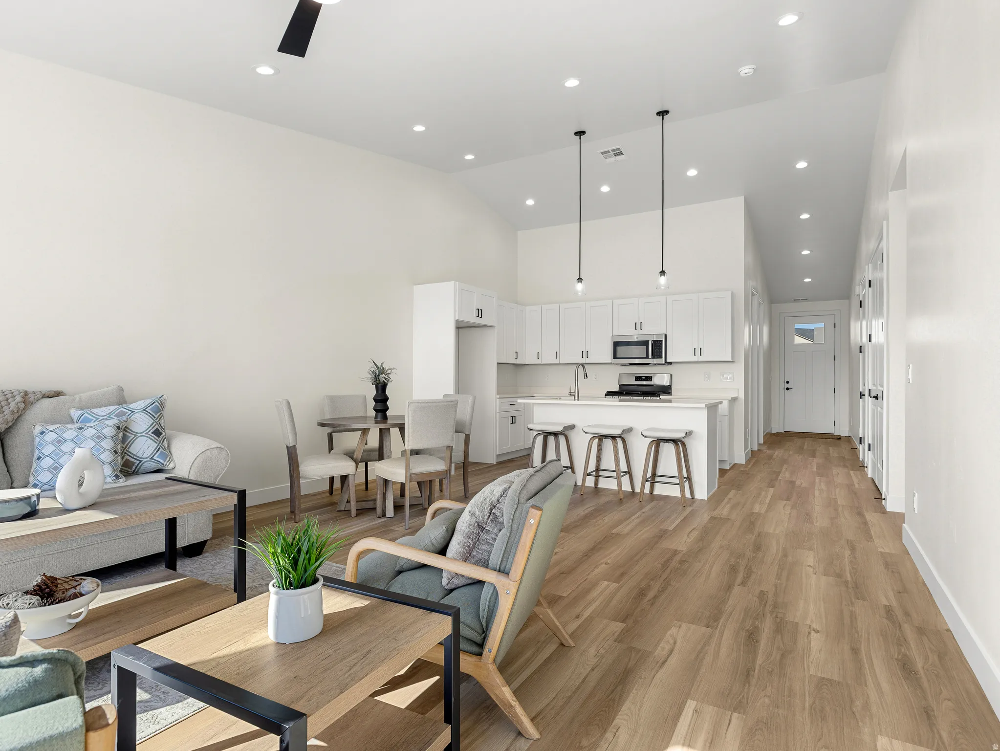 Living area with light wood finished floors, recessed lighting, and lofted ceiling