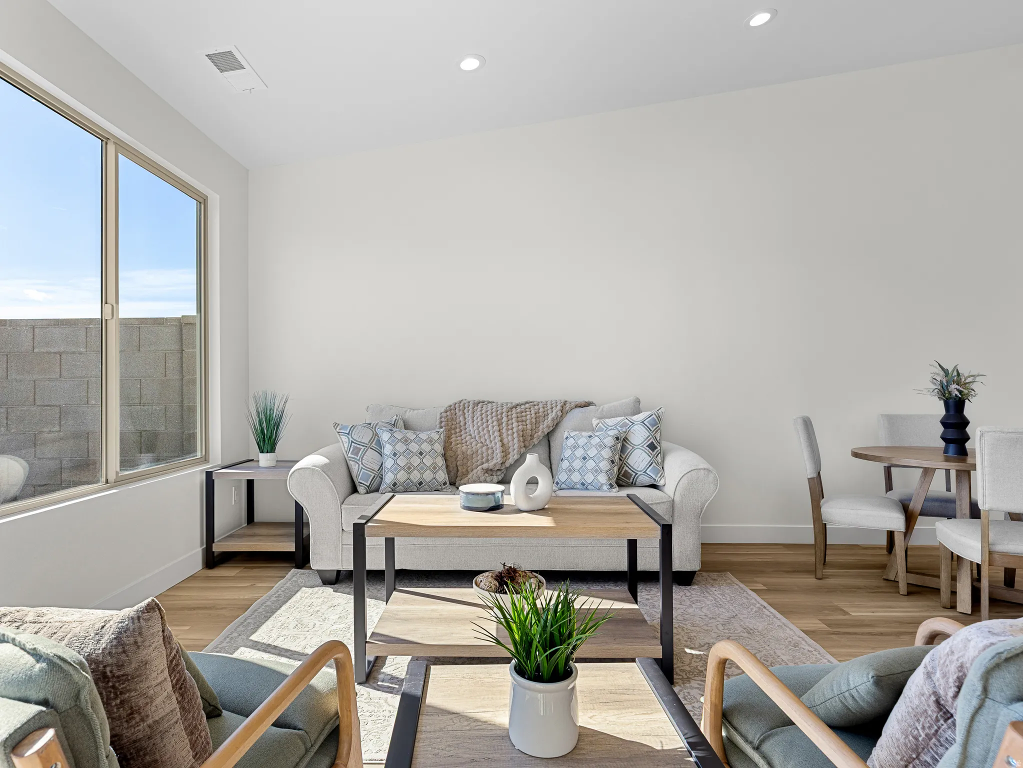 Living area with light wood-style floors and recessed lighting