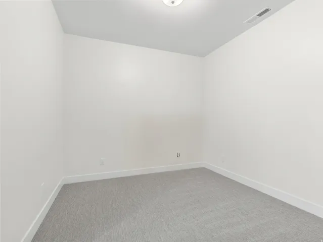 Carpeted empty room with baseboards