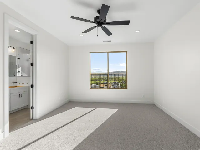 Unfurnished bedroom with carpet floors, a ceiling fan, recessed lighting, and ensuite bathroom