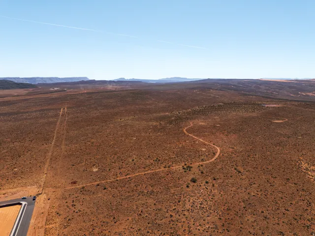 Aerial view of sparsely populated area featuring a mountain backdrop and a desert landscape