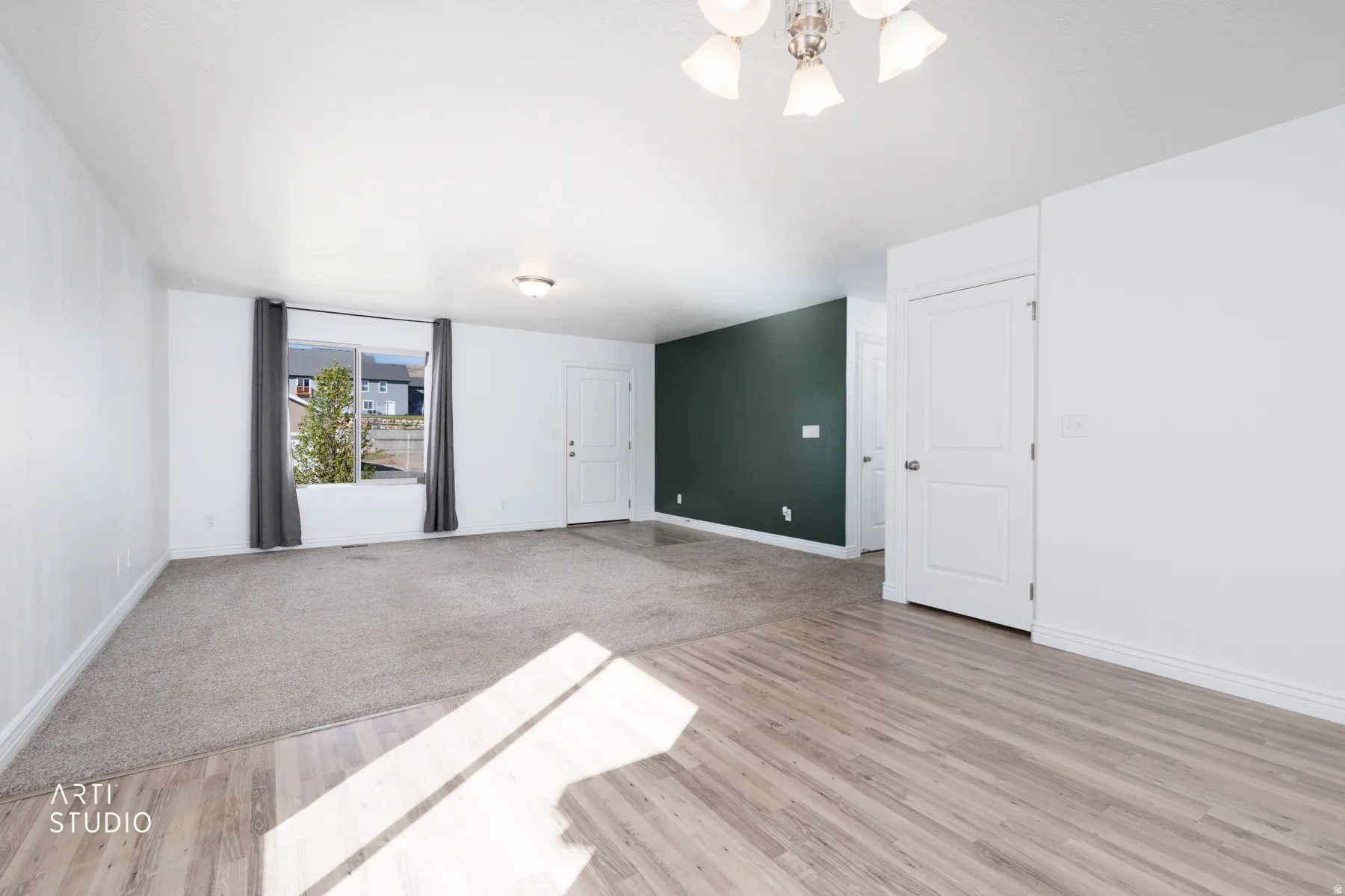 Living room featuring light carpet and wood-style floors and hanging lights