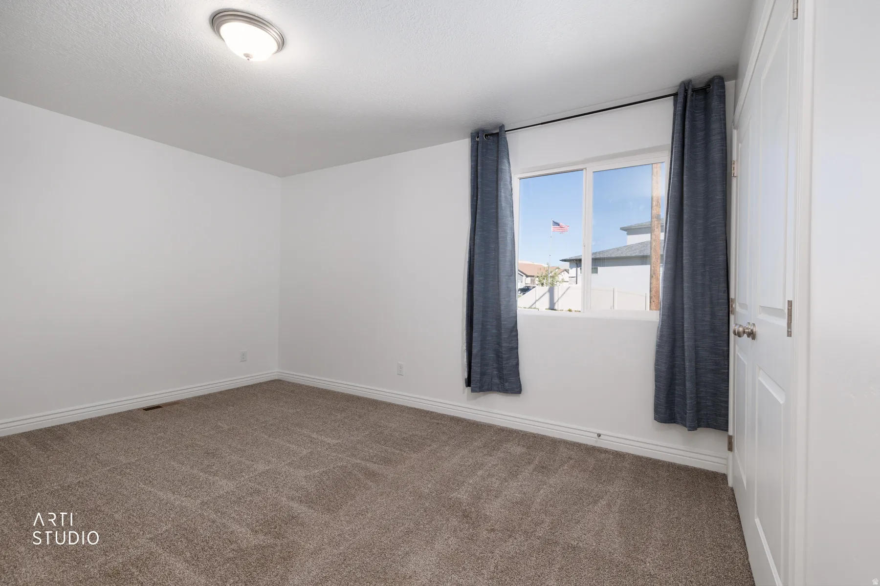Empty room featuring carpet and baseboards
