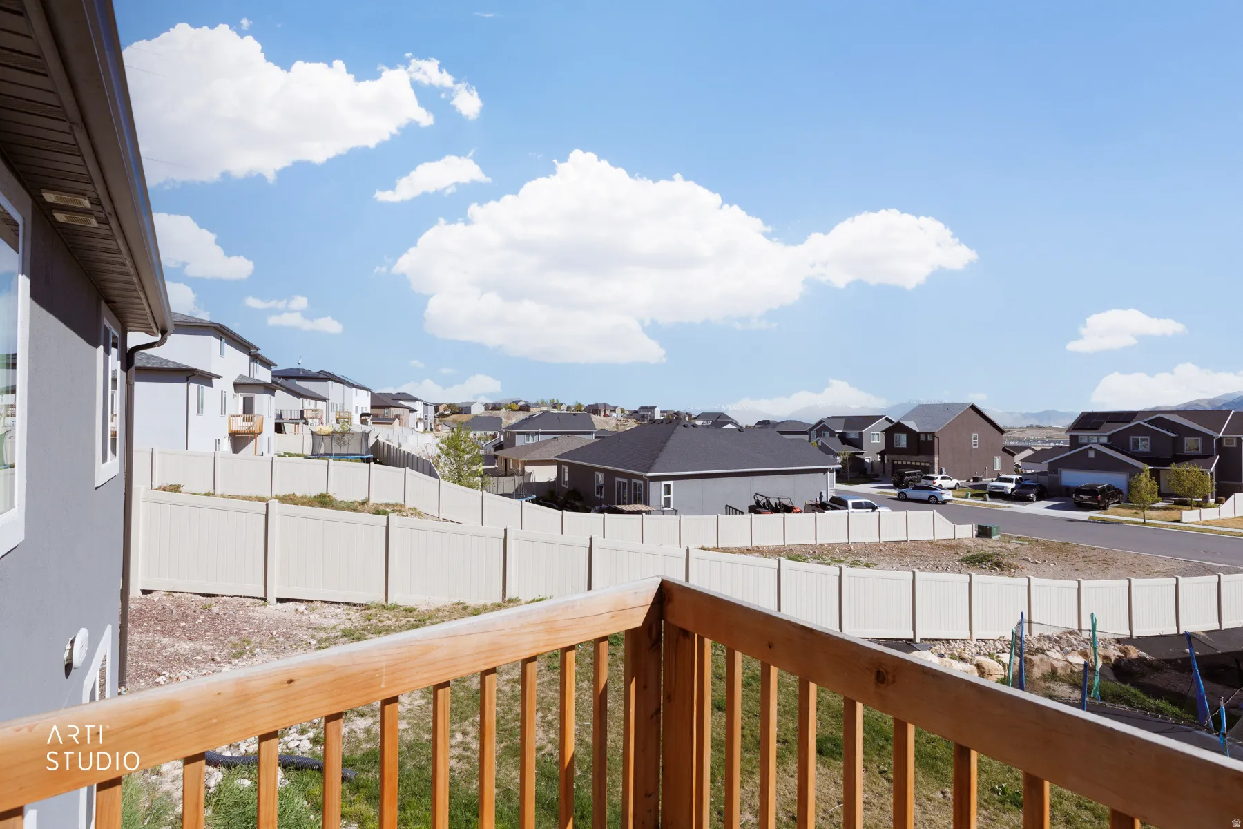 Fenced backyard with a residential view and a balcony