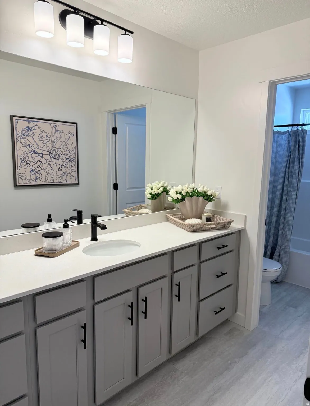 Modern bathroom featuring a vanity with light gray cabinetry, a white countertop, and a single undermount sink