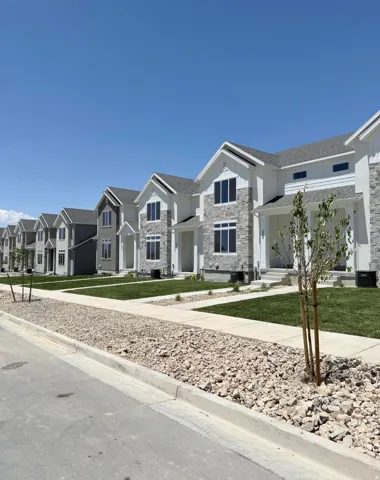 Modern residential row featuring varied facades, stone and siding exteriors, and gabled rooflines
