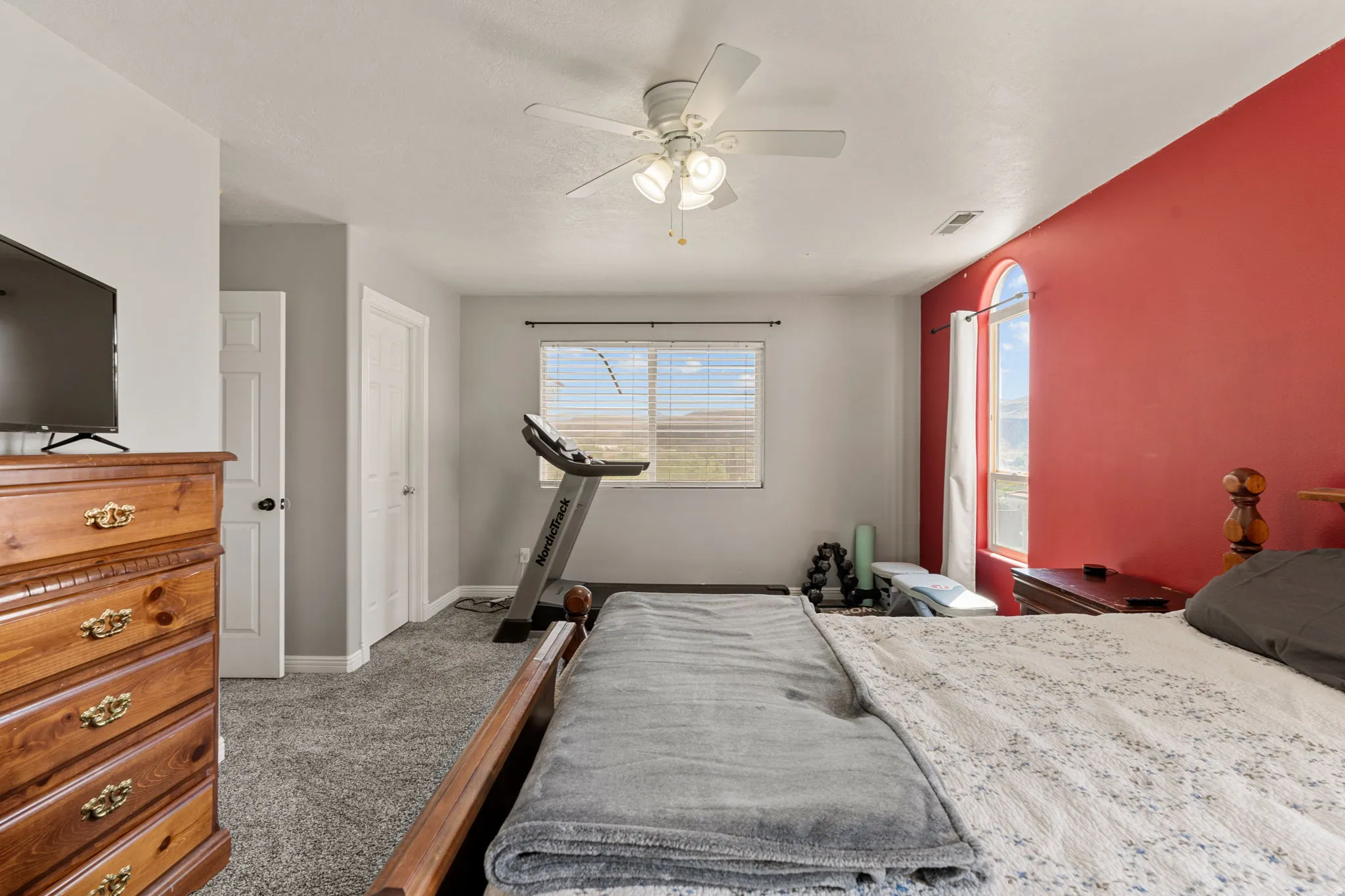 Bedroom with dark carpet and ceiling fan
