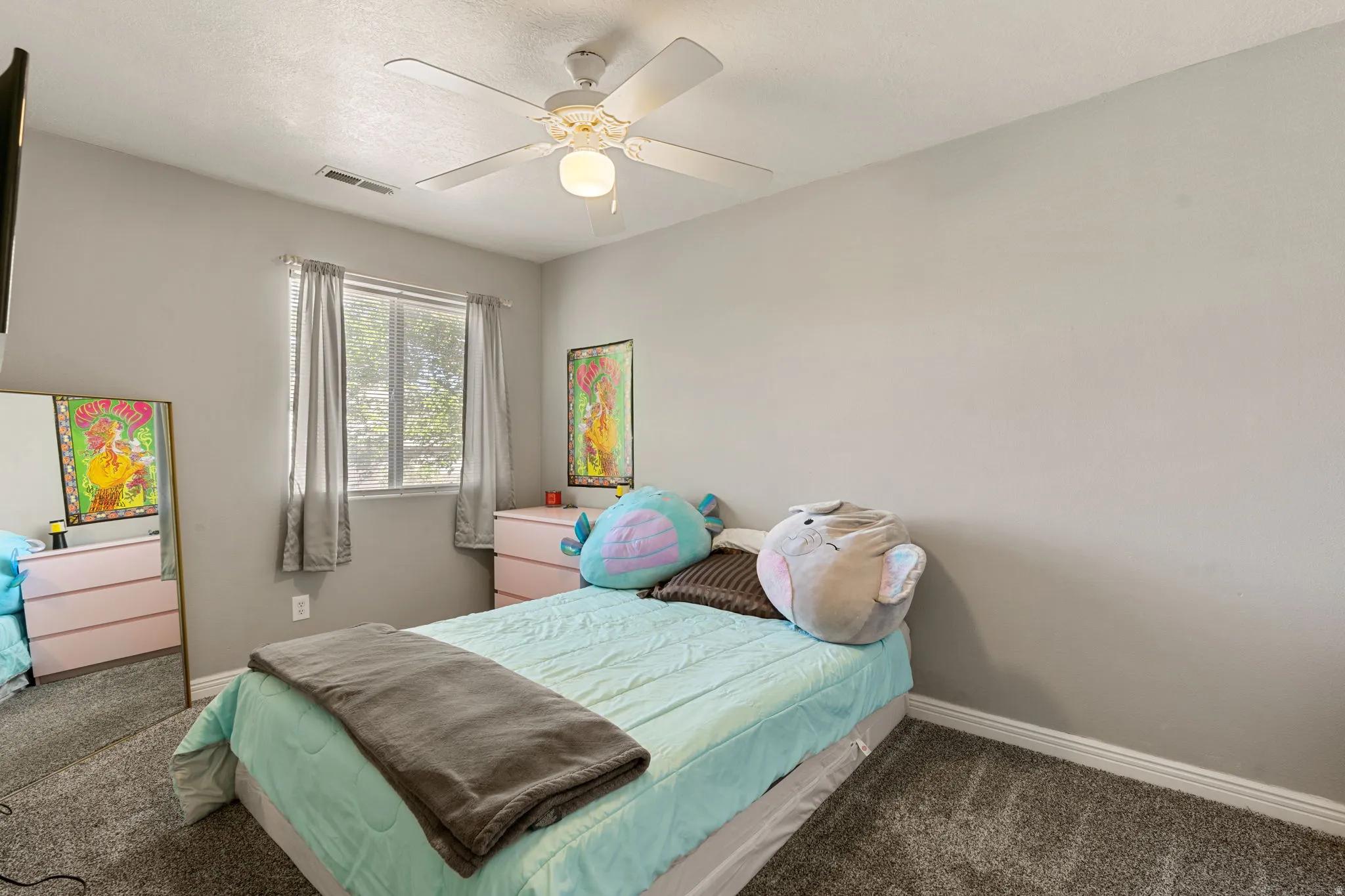 Bedroom with dark colored carpet and a ceiling fan