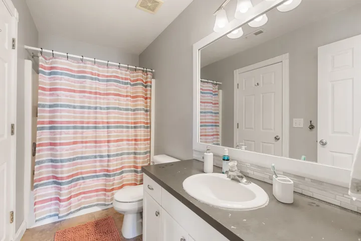 Bathroom with vanity, curtained shower, and light tile patterned flooring