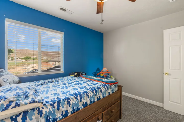 Bedroom featuring dark colored carpet and a ceiling fan
