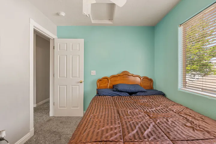 Bedroom with attic access and carpet