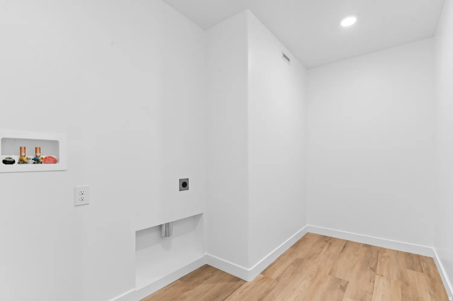 Laundry area with light wood-style floors, hookup for a washing machine, hookup for an electric dryer, and recessed lighting