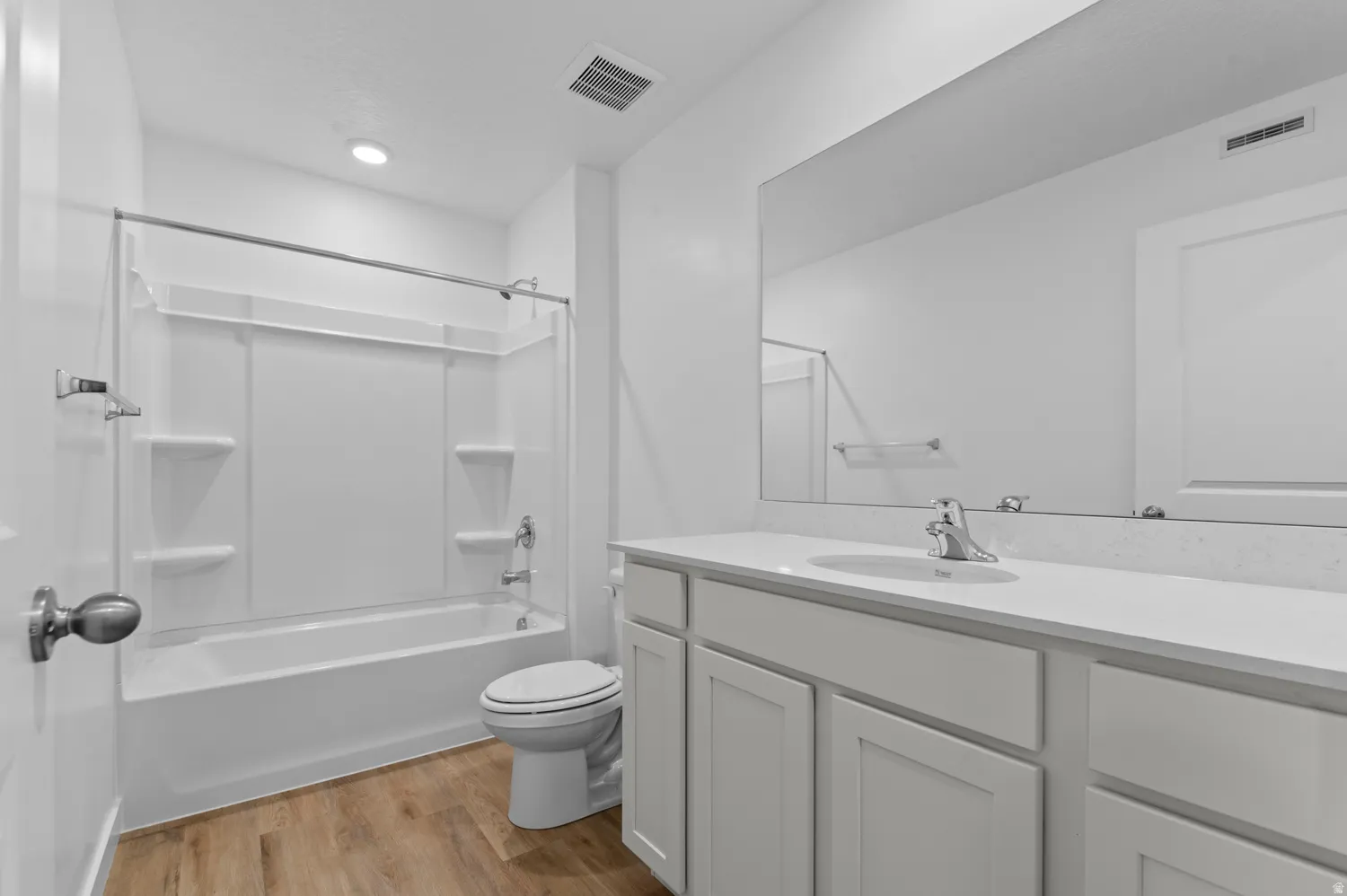 Bathroom with vanity, light wood-style floors, and shower / bath combination