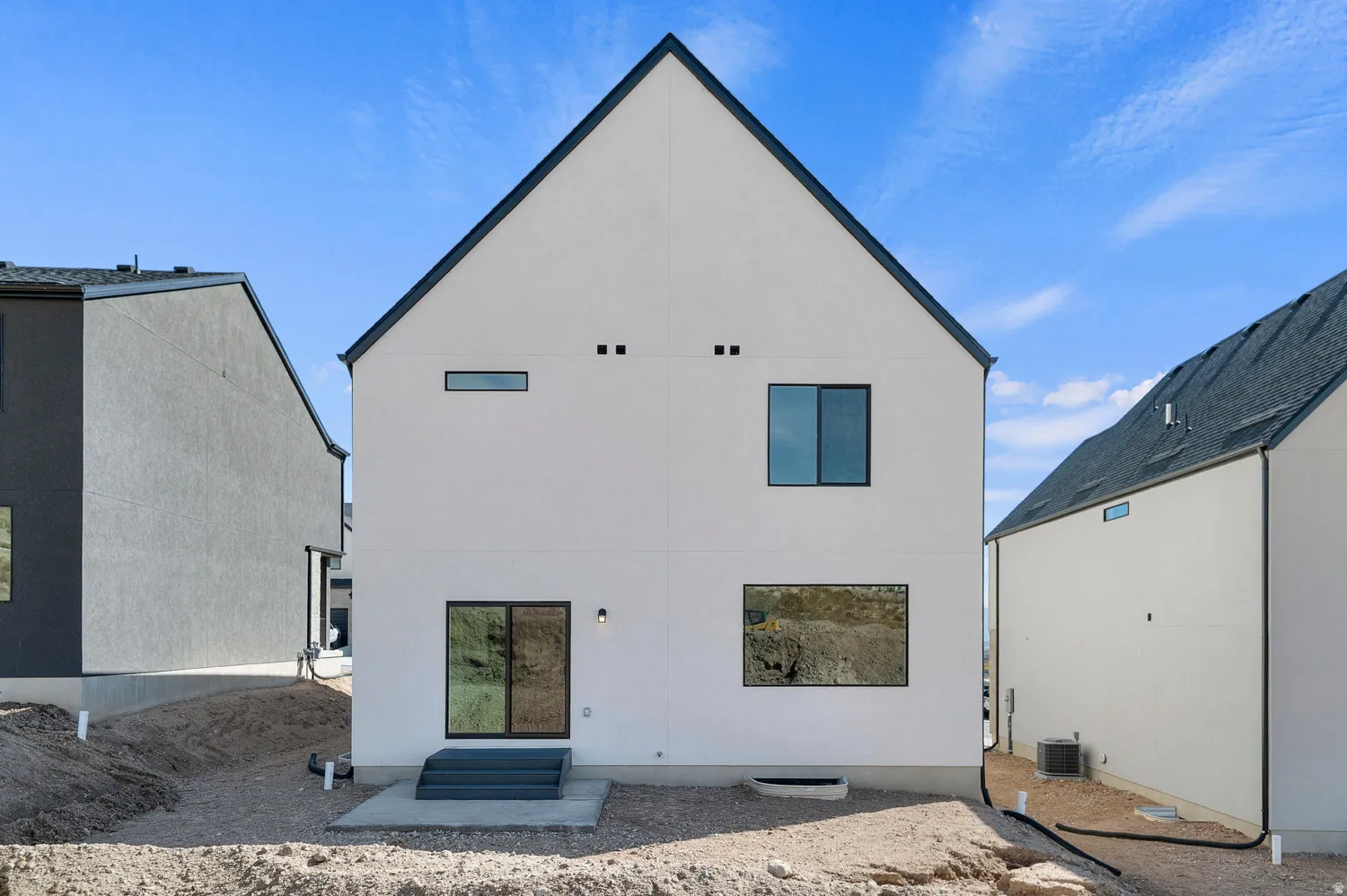 Rear view of house with entry steps and stucco siding