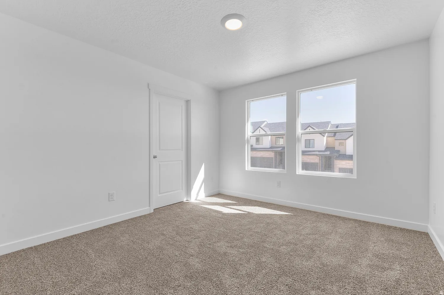 Empty room featuring carpet flooring and a textured ceiling