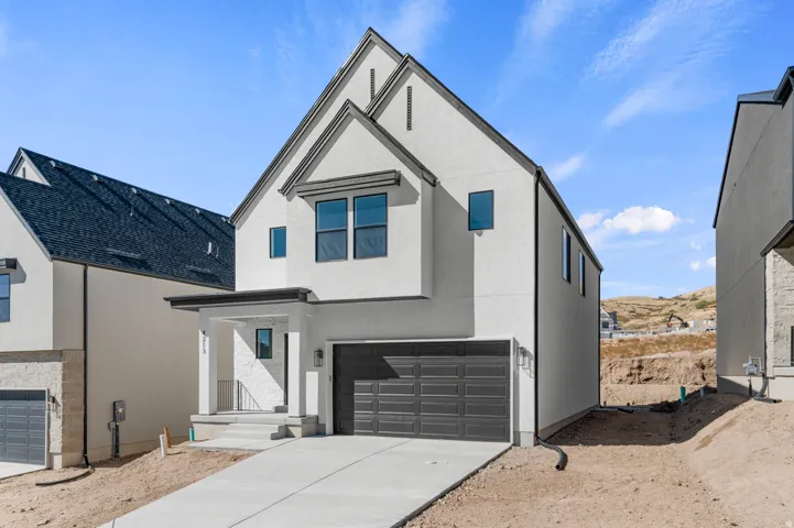 Contemporary home featuring a garage, stucco siding, and concrete driveway
