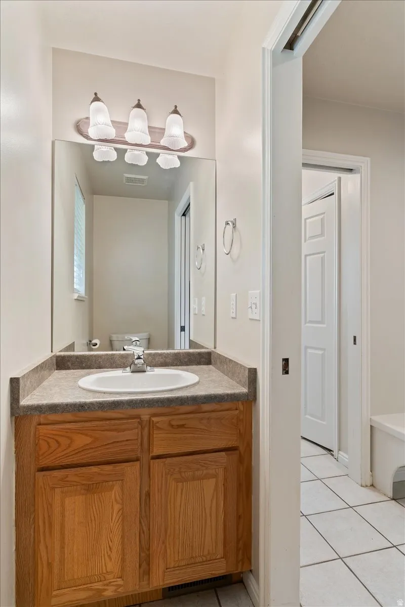 Half bath featuring vanity and light tile patterned floors