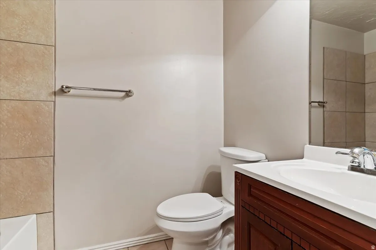 Bathroom with vanity, a tub to relax in, and light tile patterned flooring