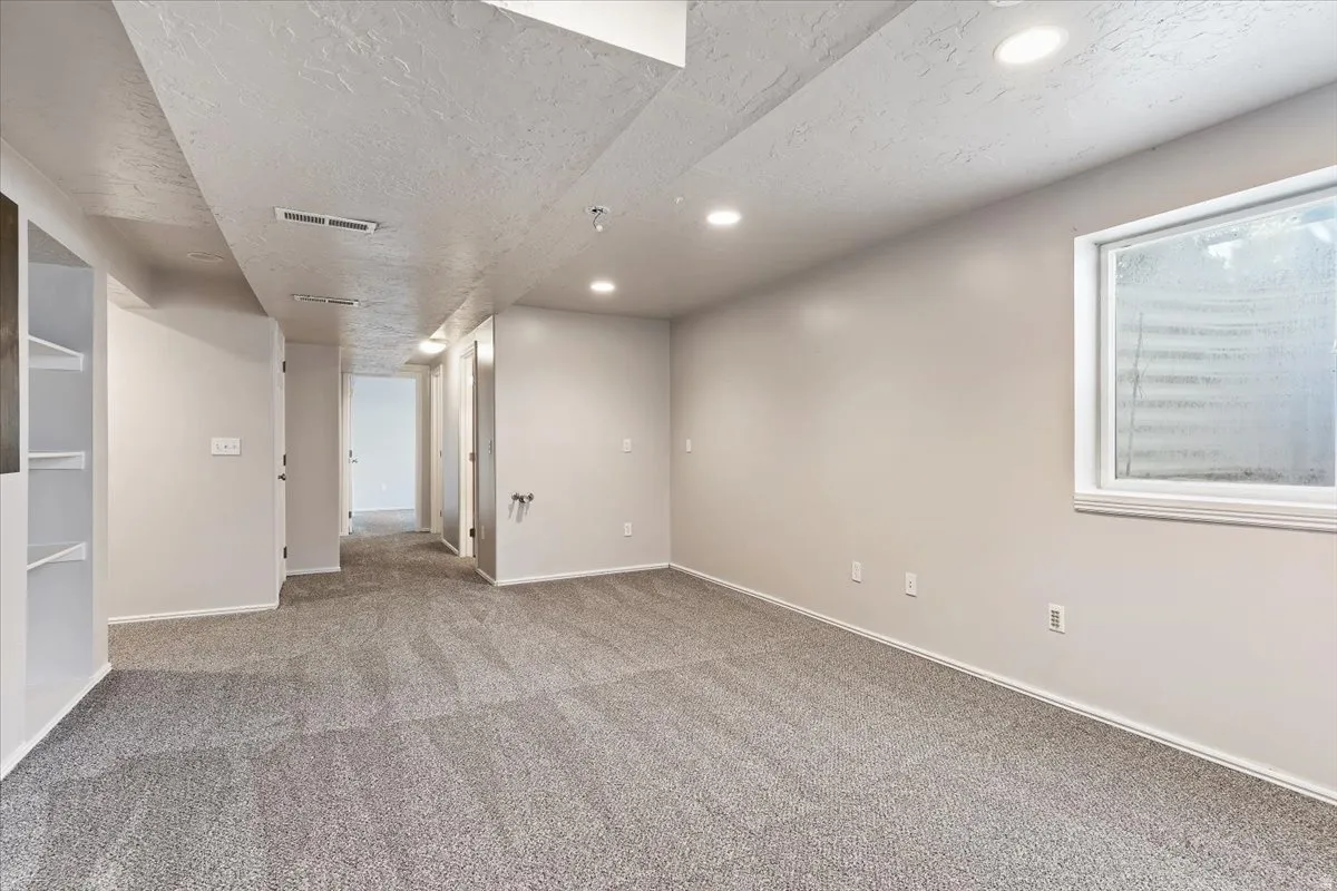 Basement with carpet flooring, a textured ceiling, and recessed lighting