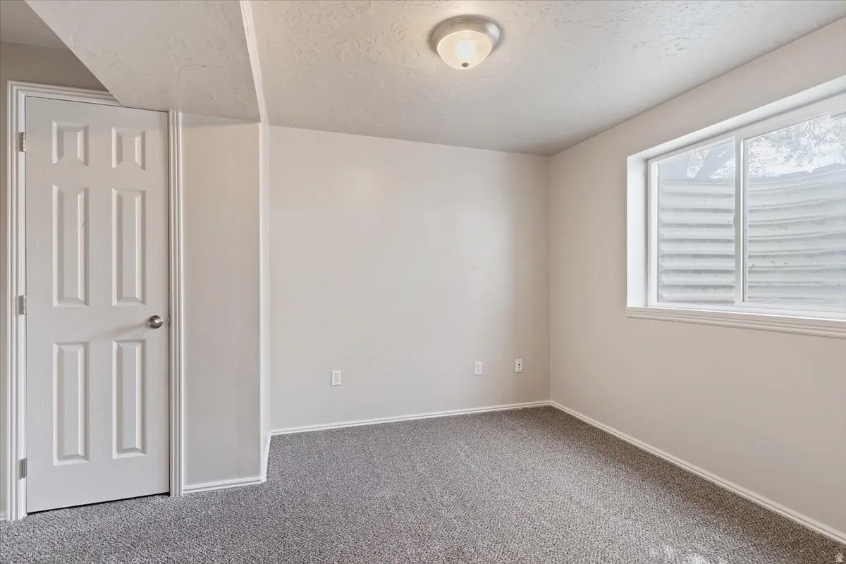 Unfurnished bedroom with a textured ceiling and carpet floors