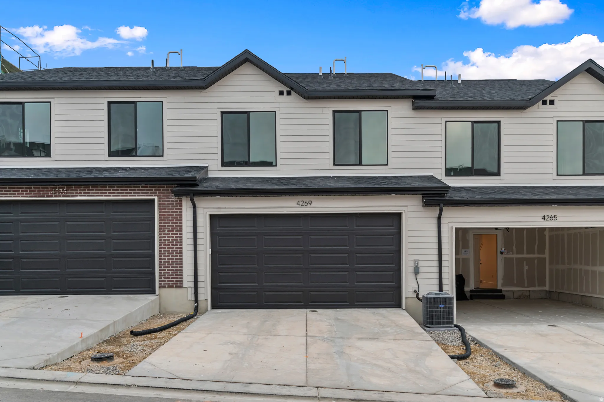 Traditional-style home with driveway, an attached garage, a shingled roof, and brick siding
