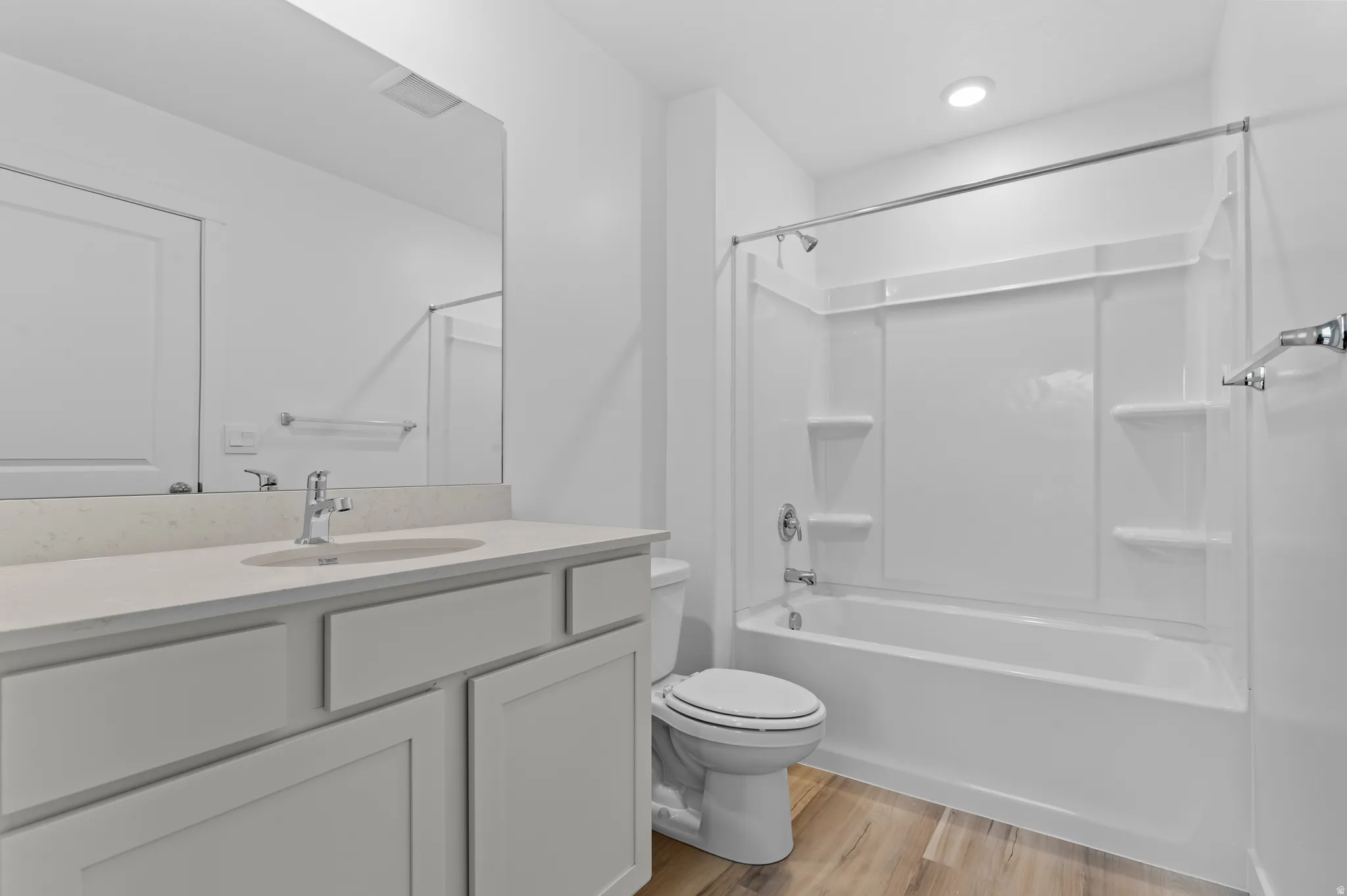 Full bathroom with vanity, light wood-style flooring, and shower / tub combination