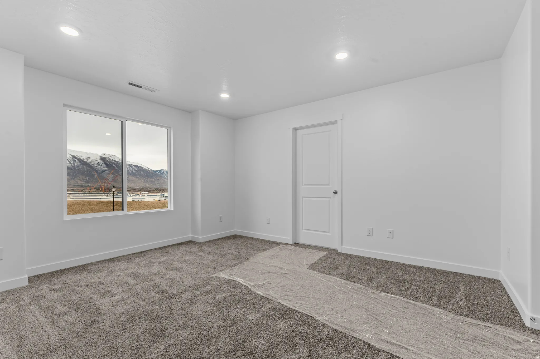Empty room with carpet floors, a mountain view, and recessed lighting