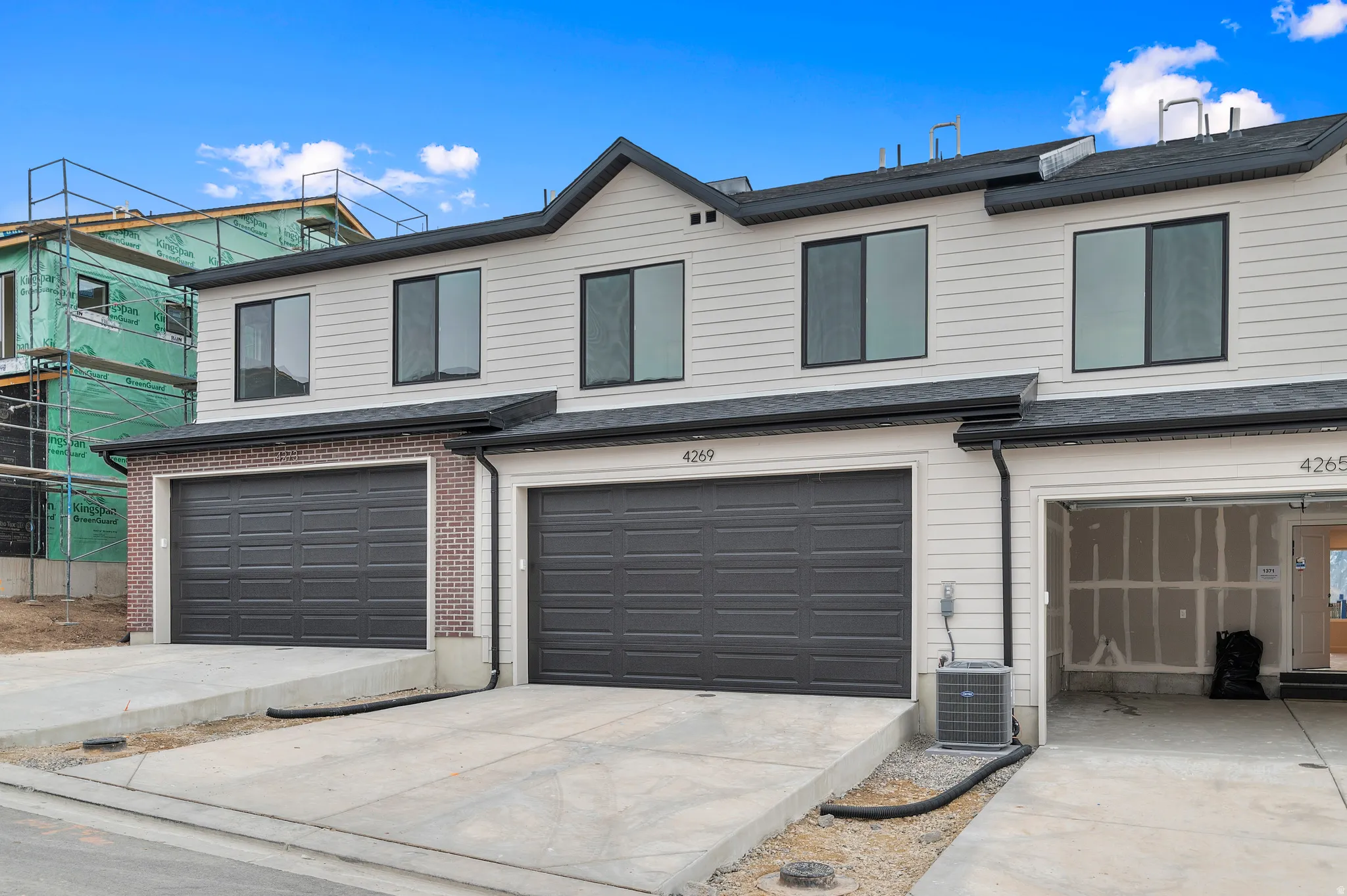 View of front of house featuring brick siding, concrete driveway, and an attached garage