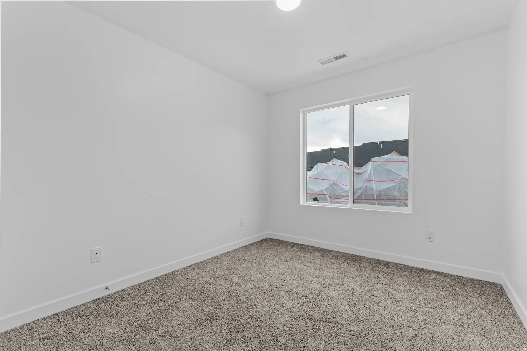Carpeted empty room featuring baseboards