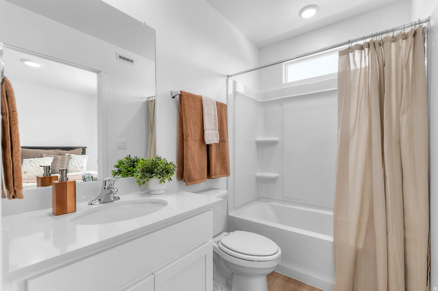 Bathroom featuring vanity, shower / bath combo, ensuite bath, and light wood finished floors