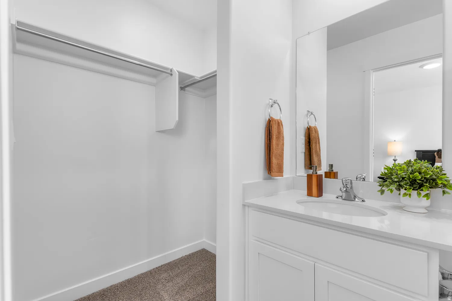Bathroom with vanity and dark carpet