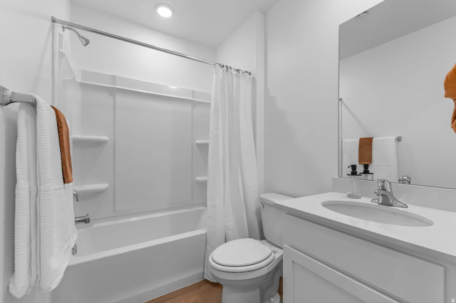 Bathroom featuring vanity, shower / tub combo, and dark wood finished floors