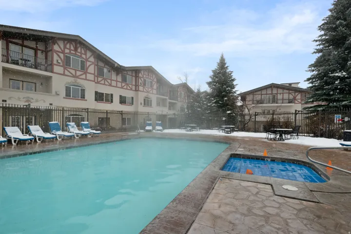 Community pool with a hot tub and a patio area
