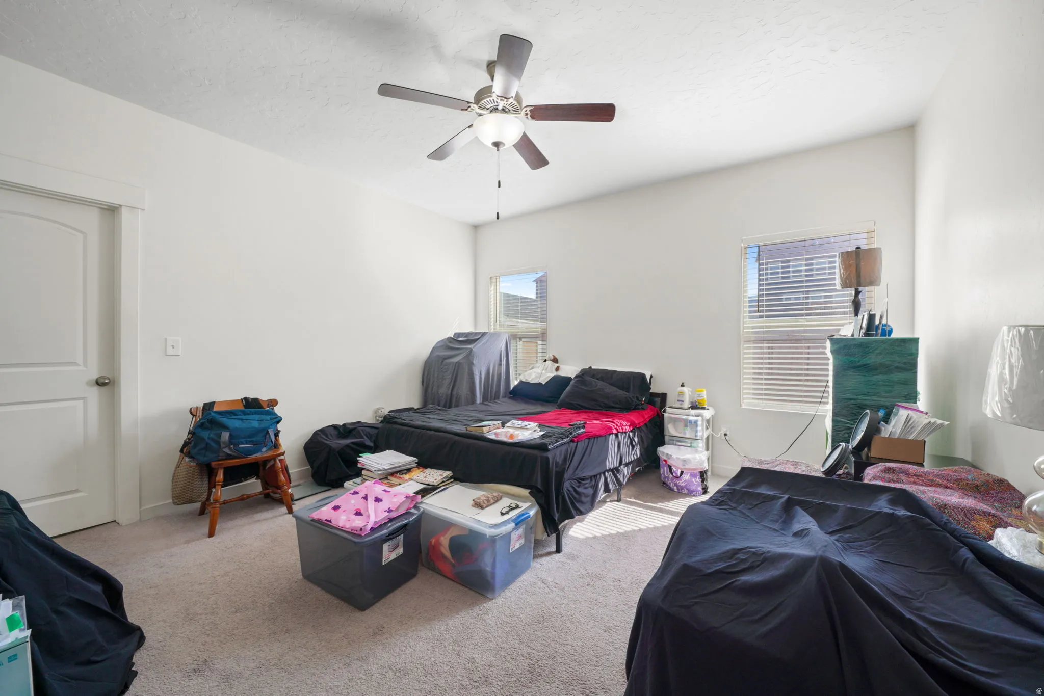 Bedroom featuring light carpet, a ceiling fan, and a textured ceiling