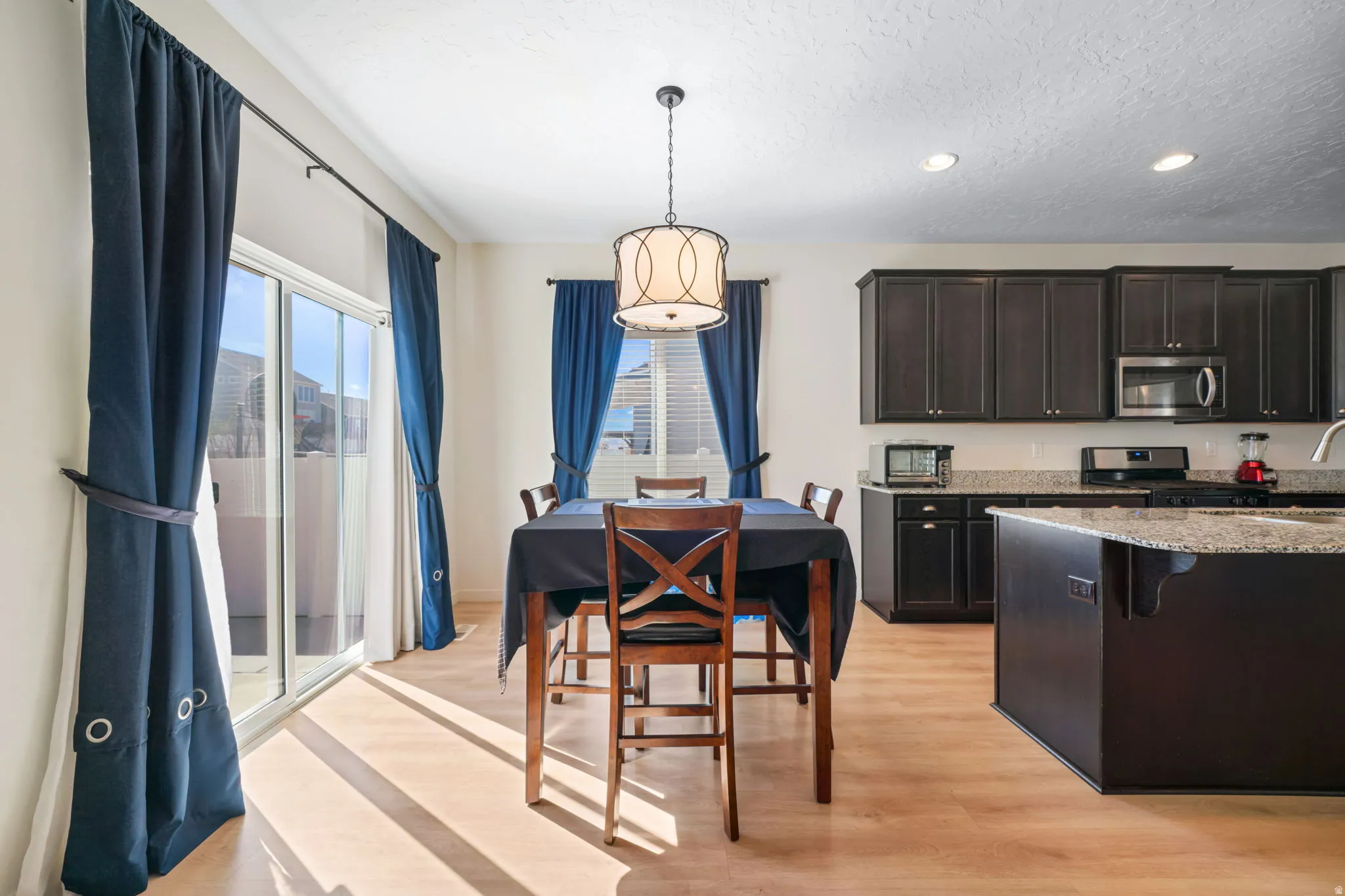 Dining area with light wood-type flooring, recessed lighting, and a textured ceiling