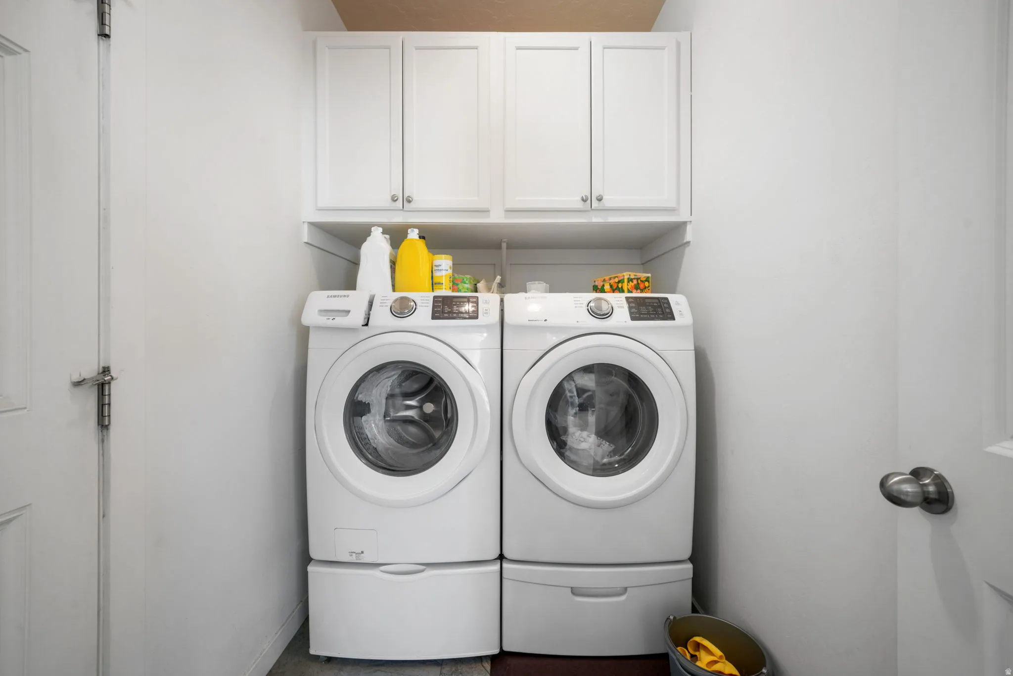 Laundry room featuring separate washer and dryer and cabinet space